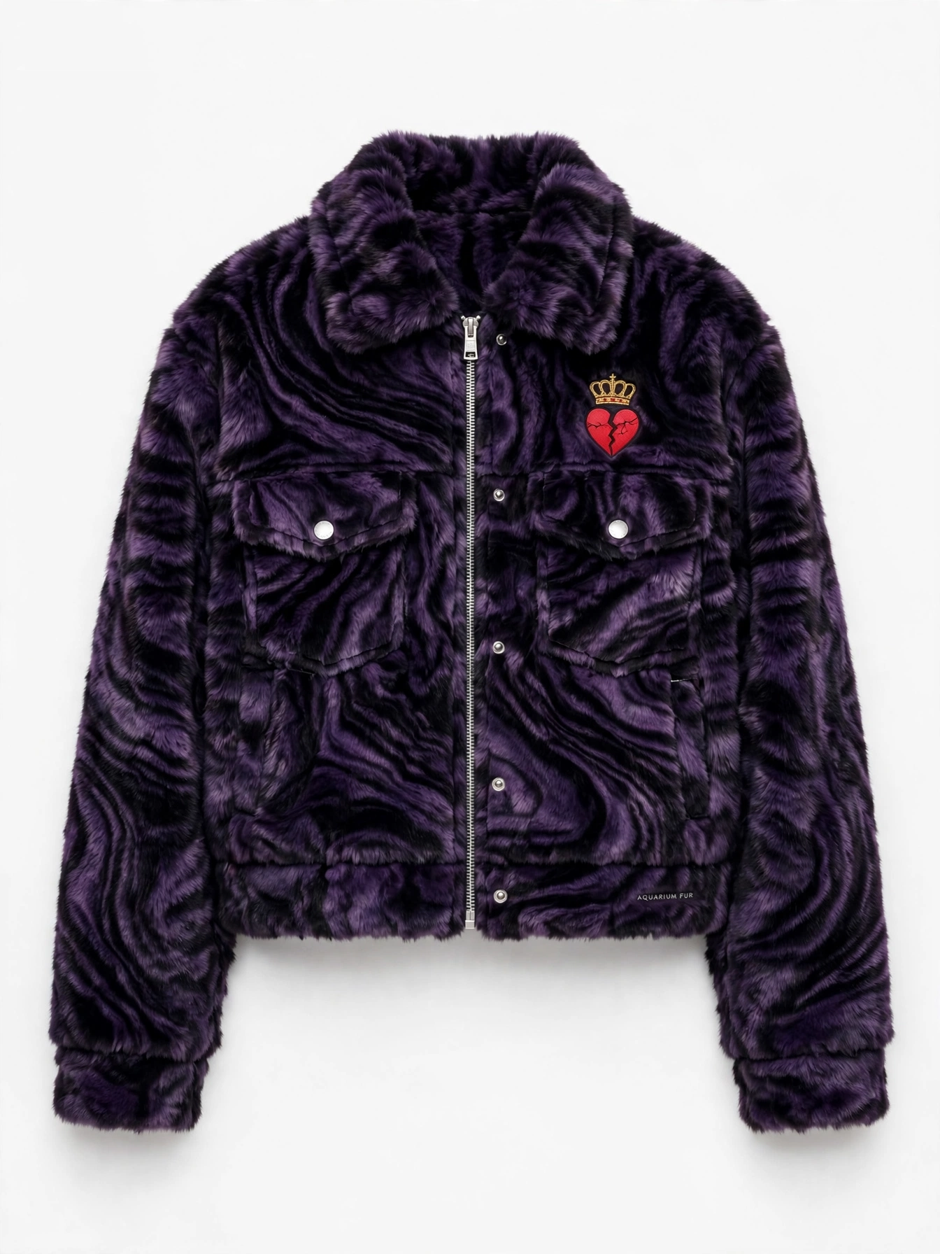 Aquarium Fur trucker jacket — cropped faux-fur trucker in deep purple and black marbled fur with silver hardware and a small embroidered gold crown over a cracked heart at the chest